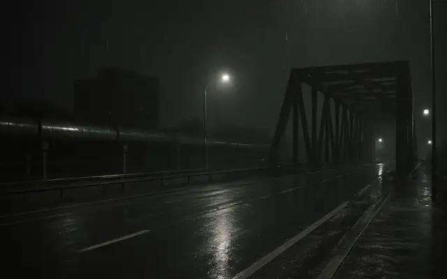 A large industrial site at night with only a few pools of light and large dark areas